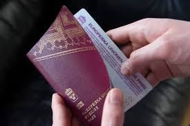 Bilden föreställer två händer som håller i ett svenskt pass.
