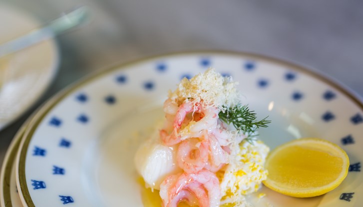 Filet de cabillaud sur une asiette blanche avec des couronnes dorées.