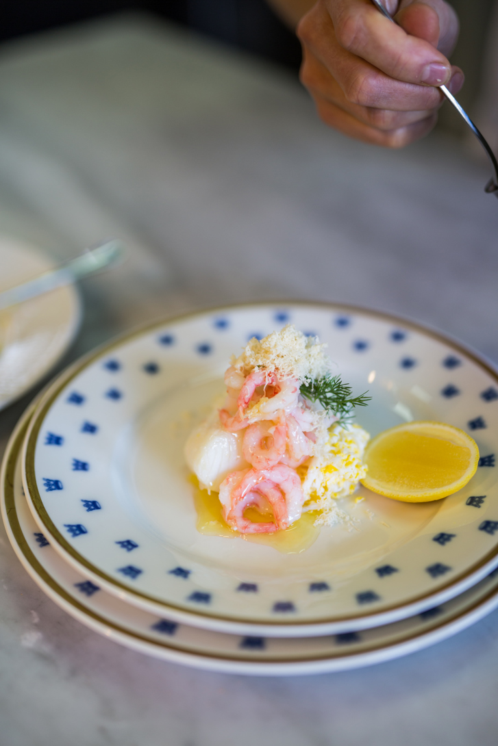 Filet de cabillaud sur une asiette blanche avec des couronnes dorées.