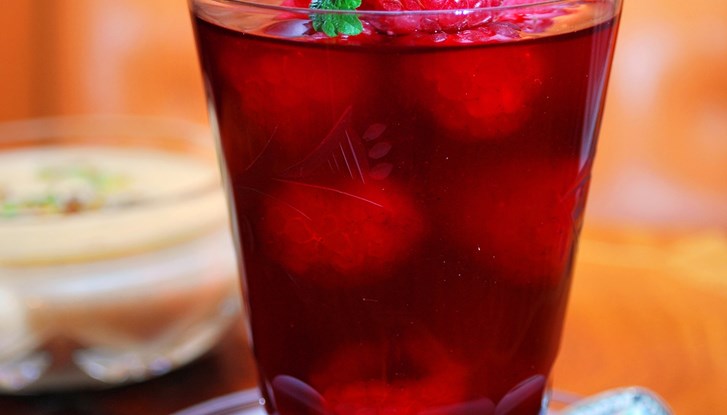 Un verre avec du gelée de framboise.