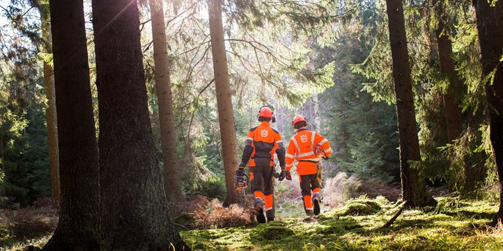Deux hommes en combinasion orange dans une forêt.