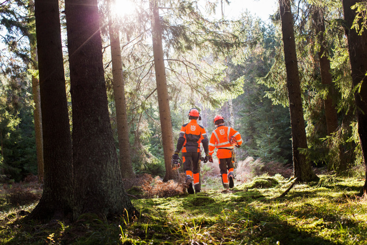 Deux hommes en combinasion orange dans une forêt.