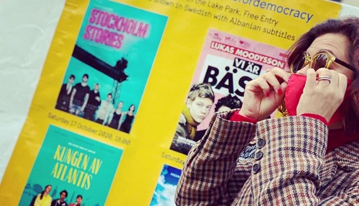 Photo of Ambassador Elsa Håstad at infront of posters at Tirana Amphitheater