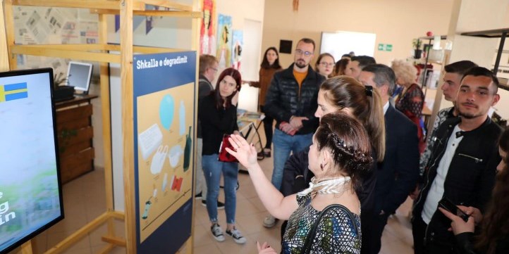 Photo of Ambassodor Elsa Håsatd pointing at the exhibition posters
