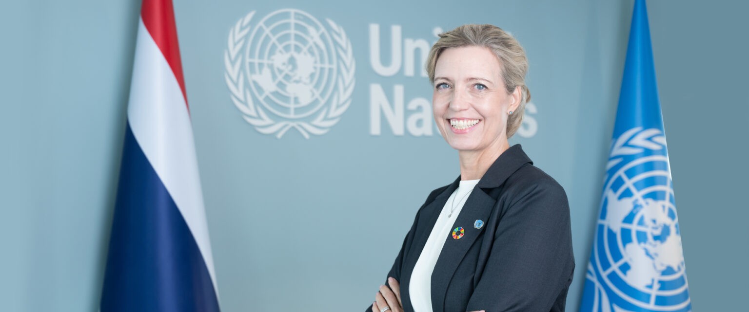 Michaela Friberg-Storey, FN:s landchef i Thailand, framför Thailands och FN:s flaggor.