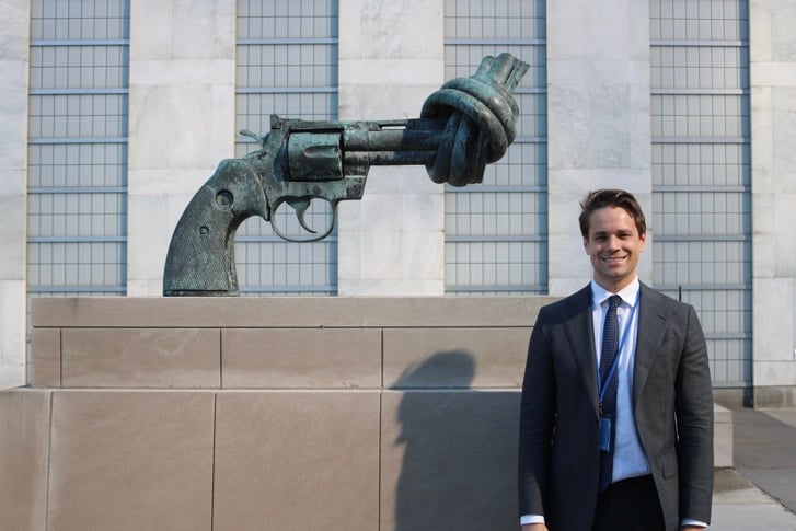 Martin Moks, Junior Professional Officer vid FN:s sekretariat, står framför skulpturen Knotted Gun utanför FN:s högkvarter i New York.
