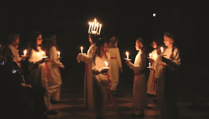 Procession de la Ste Lucie avec des jeunes gens habillés en blanc, portant des bougies.