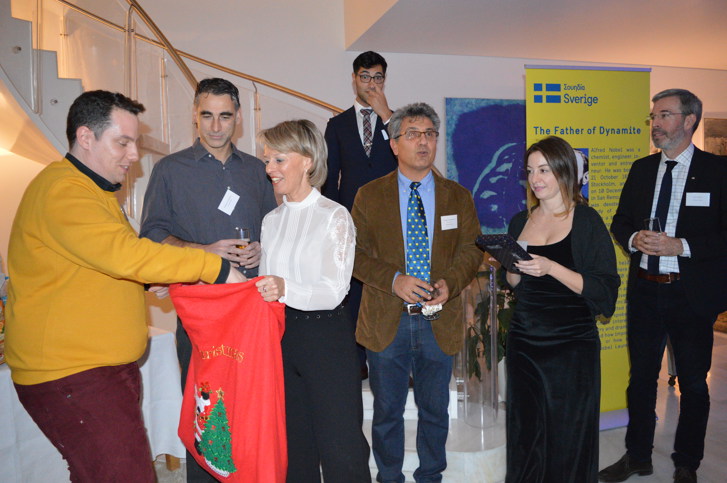 Ambassador Sammelin giving prizes to winners of the quiz.