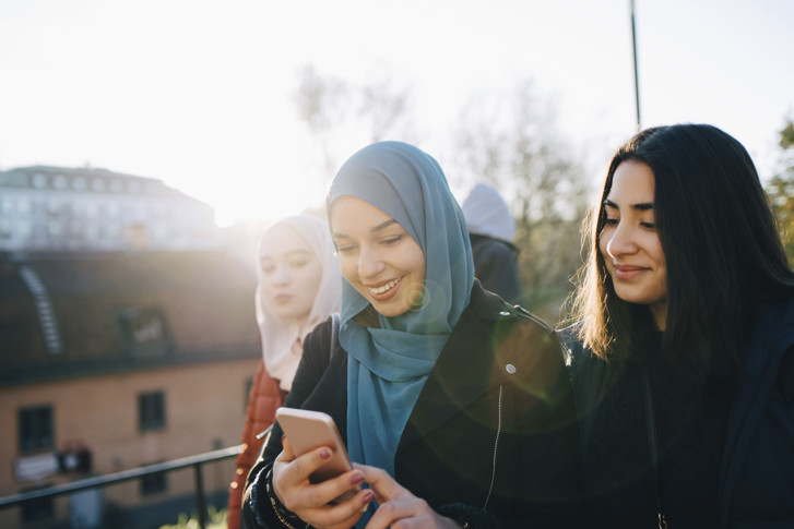 Two young girls looking to a mobile screen.