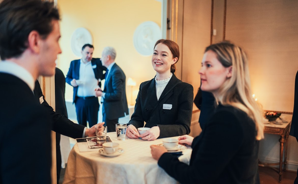 Personer runt ett ståbord som samtalar